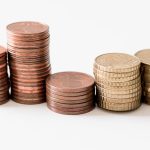 Uneven stacks of coins representing AI gross margin, token costs and MRR